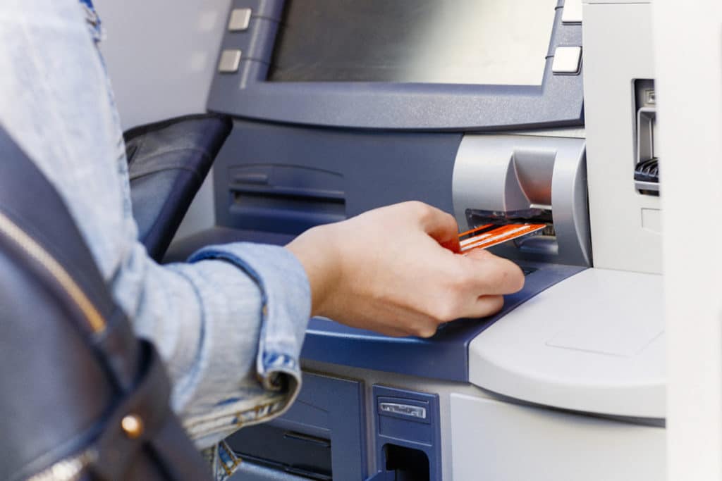A money mule beginning an illegal money transfer at the ATM.